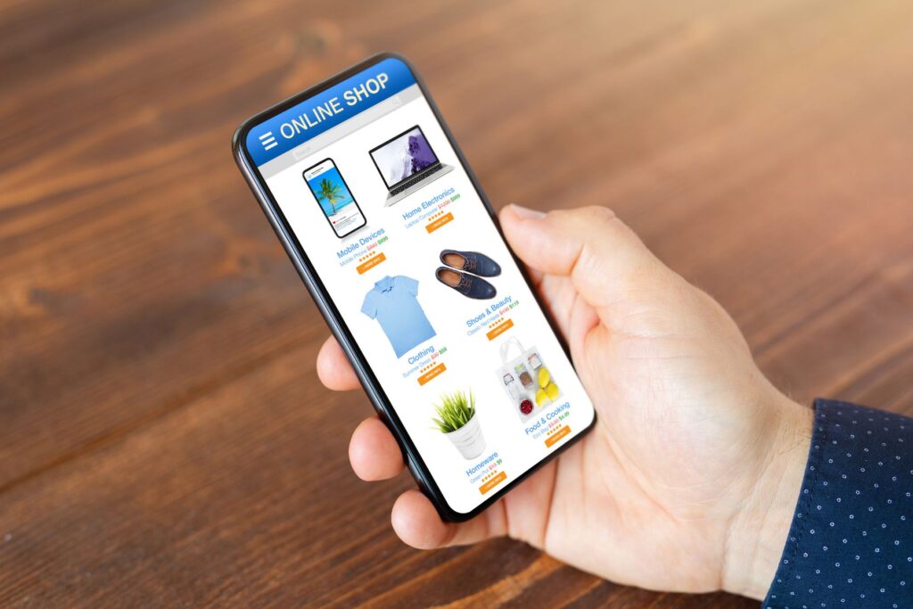 a hand holding a mobile phone showing an online shopping store selling different items